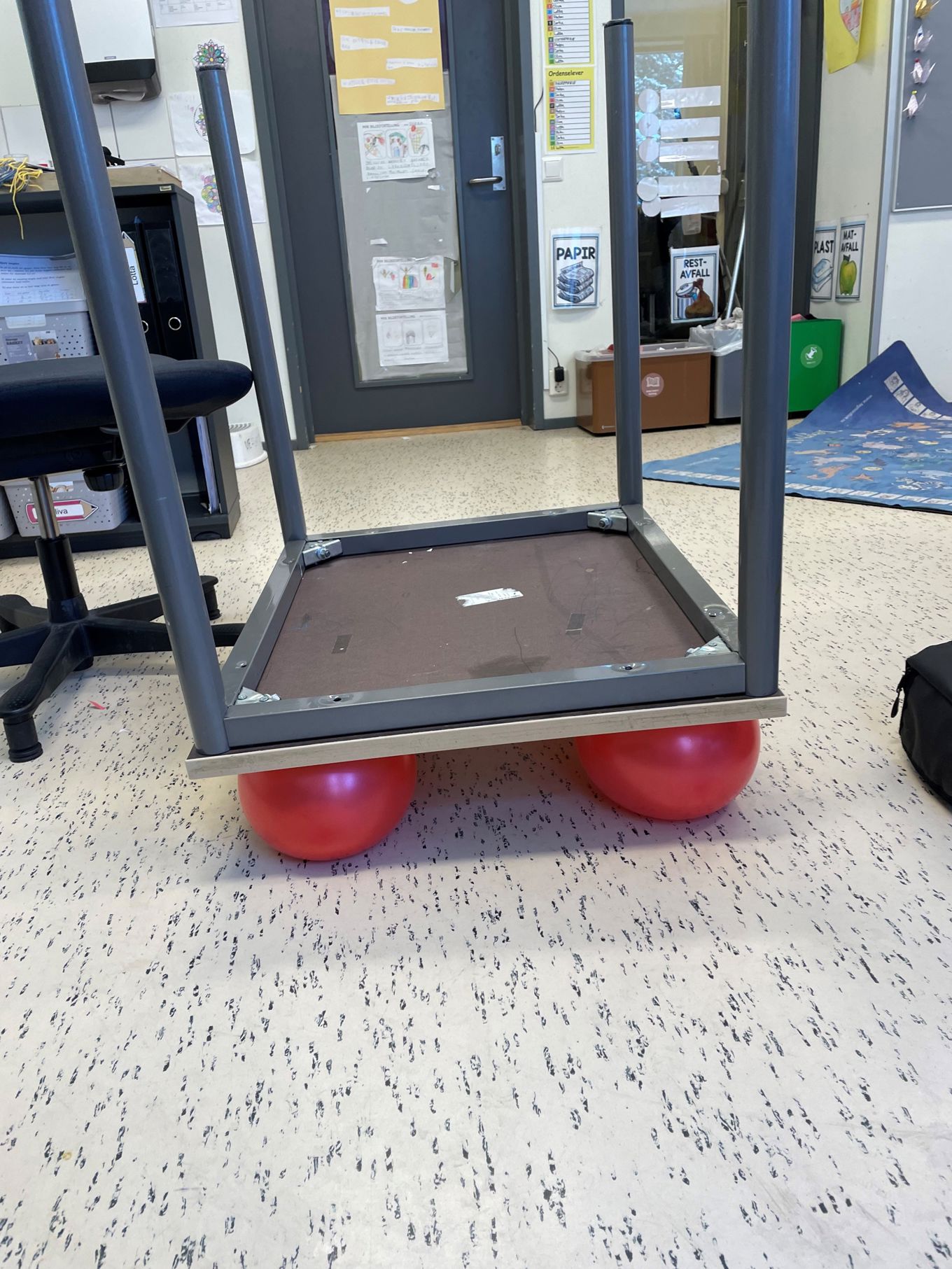 En pult ligger opp-ned oppå fire røde ballonger