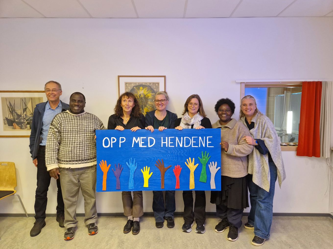 Foto: Toini Rysstad en gruppe mennesker som holder et banner hvor det står Opp med hendene