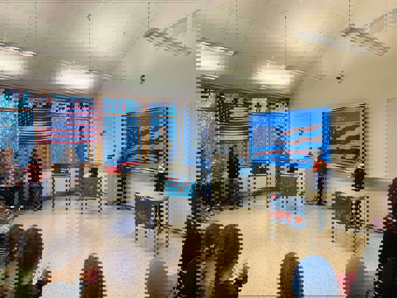 To barn som holder foredrag for flere tilhørere i et klasserom