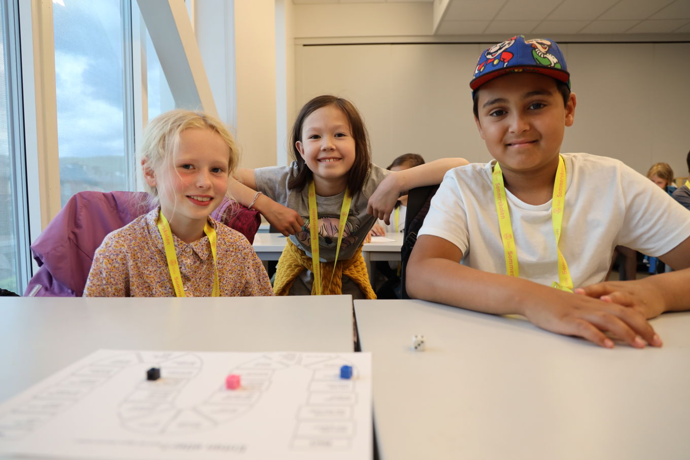 en gruppe barn som sitter ved et bord